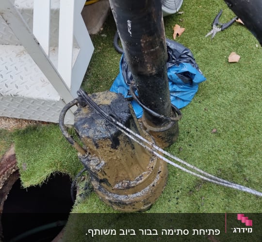 משאבה מלוכלכת ליד צינור ובור פתוח